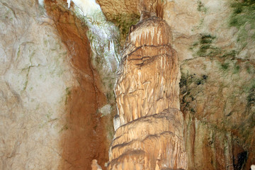Natural texture photo of wonderful natural cave with fox-coloured walls and formations of stalagmites and stalactites in it