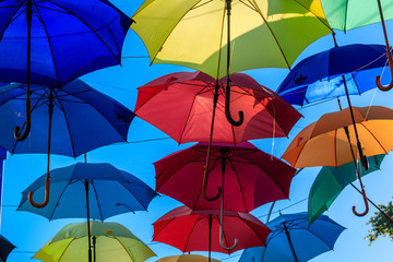 Multicolored umbrellas on the city street. The city street is decorated with many colorful open umbrellas