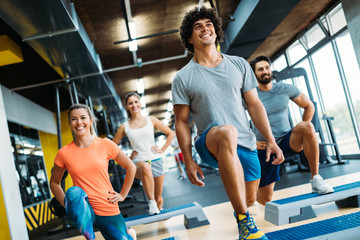 Group of young people doing exercises in gym