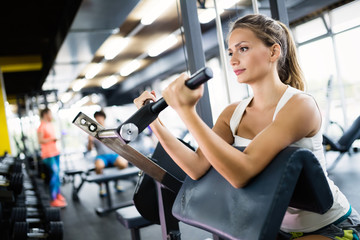 Fototapeta na wymiar Woman working out in gym on machine
