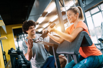 Young beautiful woman doing exercises with personal trainer