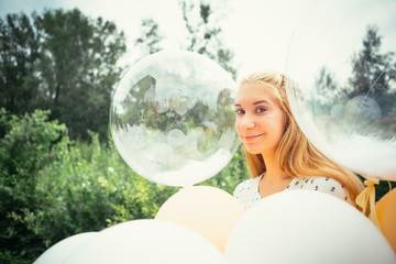 Naklejka premium portrait of young girl with balloons on nature background