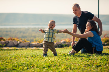Happy family with baby on green grass