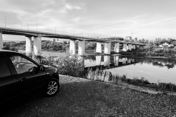 Travel, car on the river Bank. River bridge. Two banks. Monochrome photos