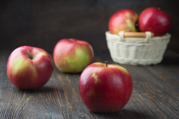 Red apples in a wooden bucket. On a rustic background.