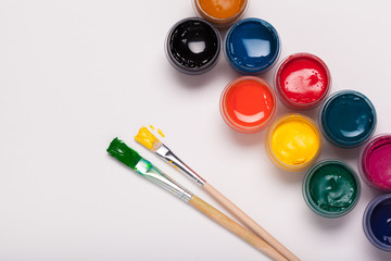 Paper, watercolors, paint brush and some art stuff close up top view