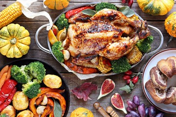 Thanksgiving day food. Festive family dinner table with roasted chicken or turkey and various of vegetables. 