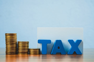 TAX concept. TAX alphabet with stack of coin and business card or name card on wooden working table, business and financial concept.