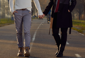 Couple using cellphone while drinking coffee outdoors.