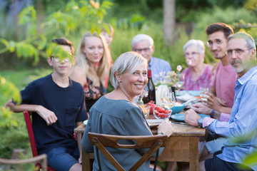 Summertime, cheerful family gathered for picnic in the garden