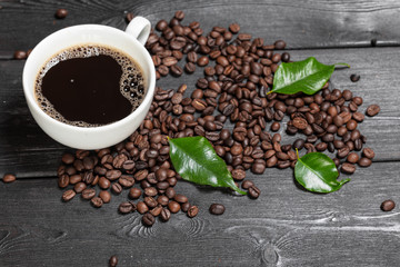 Cup of coffee and beans on wooden background