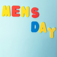 International men's day inscription in multicolored letters on a blue background. concept men