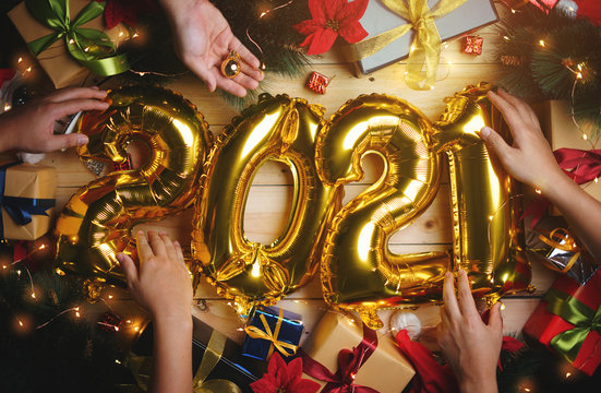 People Decorating 2021 Golden Balloon Between Christmas Decoration. Top View