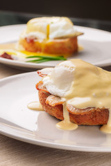 Breakfast is Eggs Benedict - toasted English muffins, bacon, ham, poached eggs, herbs and delicious buttery hollandaise sauce.