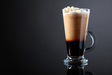 Coffee drink or cocktail with cream on a black background.