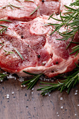 Raw pork with rosemary , salt and pepper.