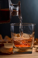  Whiskey is poured into a glass from a carafe.