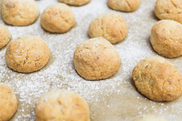 Fototapeta na wymiar Fresh bakened Christmas nut cookies with icing sugar on baking tray