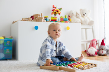 Cute little baby boy, playing with abacus at home