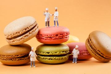 miniatures peoples : chefs in front of delicious macaroons