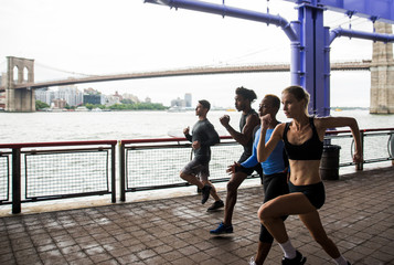 Group of urban runners running on the street in New york city, conceptual series about sport and fitness - obrazy, fototapety, plakaty