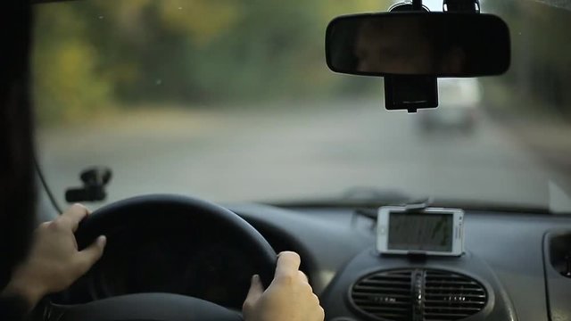 Man rides a car with a navigator on a smartphone, soft focus