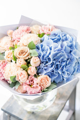 beautiful spring bouquet. flowers arrangement with various of colors in glass vase on old table. bright room, white wall. copy space