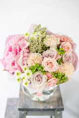 beautiful spring bouquet. flowers arrangement with various of colors in glass vase on old table. bright room, white wall. copy space
