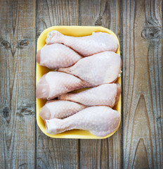 fresh raw chicken pieces on a wooden background in a tray