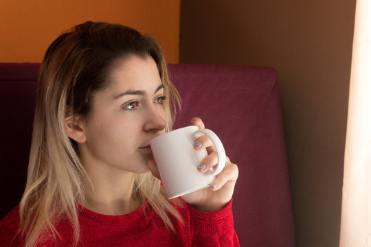 Mujer relajante en casa sosteniendo una taza de caf&eacute;