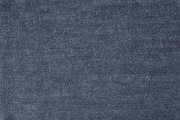 Old blue denim jeans texture or background with visible fibers 