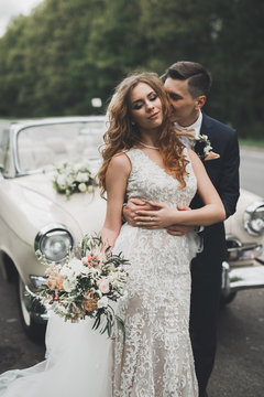 Just married couple in the luxury retro car on their wedding day