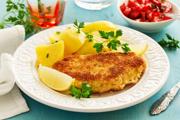 Baked chicken breast with a crispy crust, served with boiled potatoes.