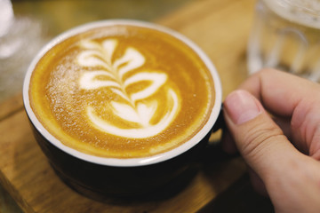 man's hand catch the hot latte coffee