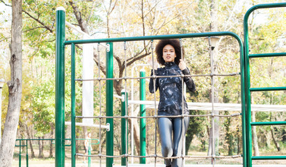 Smiling Mixed Race Young Woman Exercise At Outdoor Fitness Park