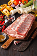 Heart shape Raw fresh meat Ribeye Steak with rosemary, pepper and salt on stone slate background