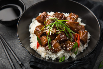 sweet sticky pork served with chives and  sesame seeds