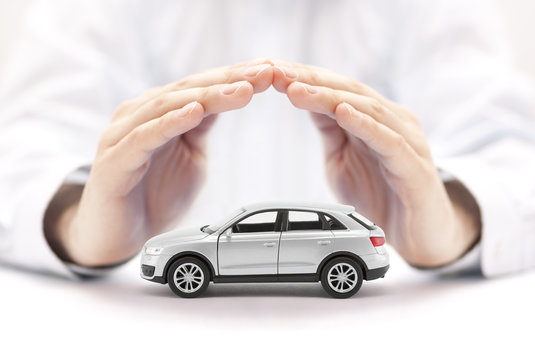 Fototapeta Car insurance. Small silver car covered by hands.
