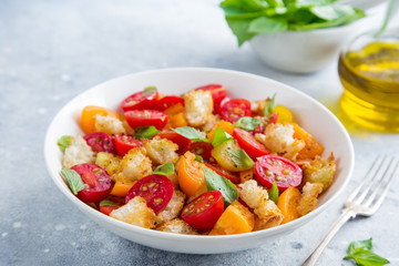 panzanella, traditional italian tomato and bread salad in white bowl