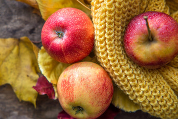 red apples autumn leaves on wooden background
