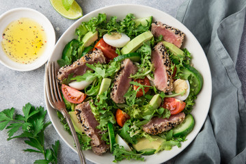 grilled tuna, avocado, tomato and egg salad in white bowl