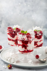 Eton mess, traditional english dessert, meringues, whipped cream, berry sauce and fresh raspberry in  glass
