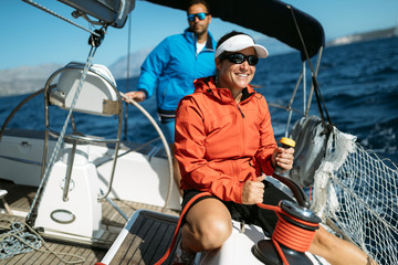 Attractive strong woman sailing with her boat