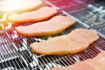 Crédence de cuisine en verre imprimé Viande Pieces of meat on conveyor belt machine
