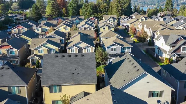 Flying over an American suburban neighborhood with many small houses in close proximity; 4k footage