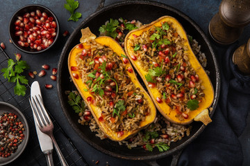 butternut squash stuffed with brown rice and vegetables, served with pomegranate and coriander
