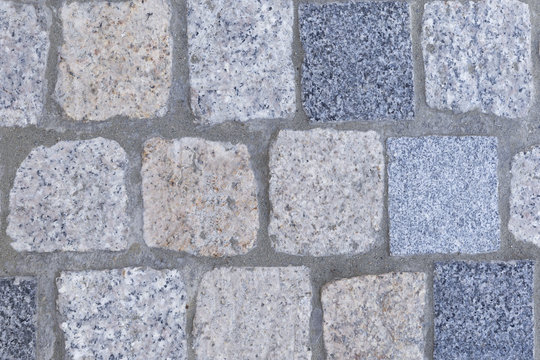 background of beige dark tery and light granite square paving stones and tiles