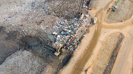 Garbage pile in trash dump or open landfill, Trash trucks dump waste products polluting in an trash dump, Surface and subsurface water contamination, modern hydraulic. Aerial top view