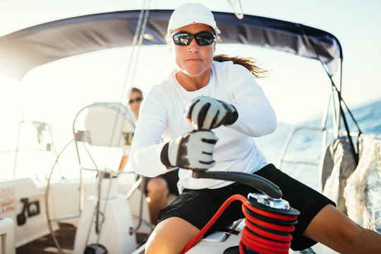 Attractive strong woman sailing with her boat