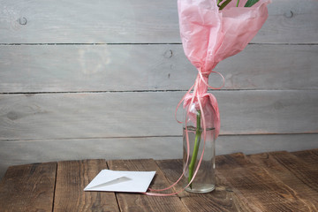 a vase with envelope on wooden grey background